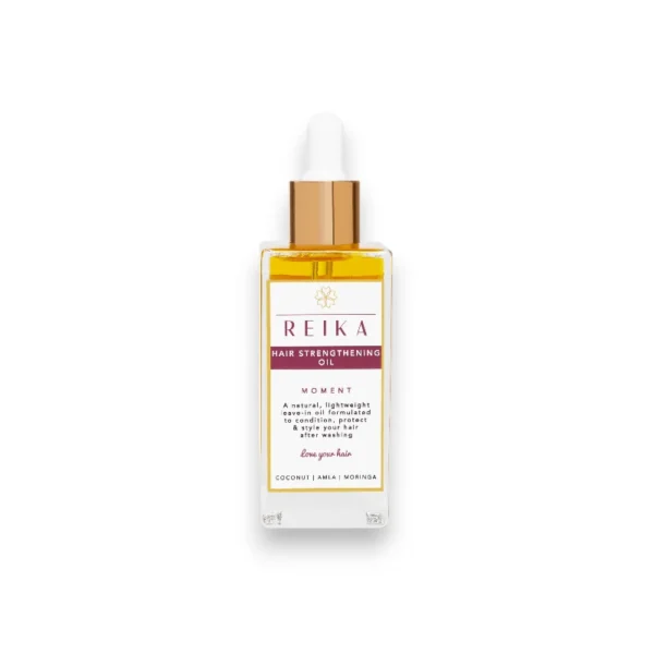 The image showcases the packaging for REIKA Hair Strengthening Oil in a sleek rectangular bottle with a golden dropper cap. Key Features: The brand name "REIKA" is prominently displayed with a minimalistic flower emblem above it. The product title, "Hair Strengthening Oil," is in bold white text on a burgundy band. A tagline, "MOMENT," is highlighted below, evoking a sense of luxury and nourishment. Product description: "A natural, lightweight leave-in oil formulated to condition, protect & style your hair after washing." Core ingredients are listed at the bottom: "Coconut | Amla | Moringa." A loving message: "Love your hair" is added for a personal touch.